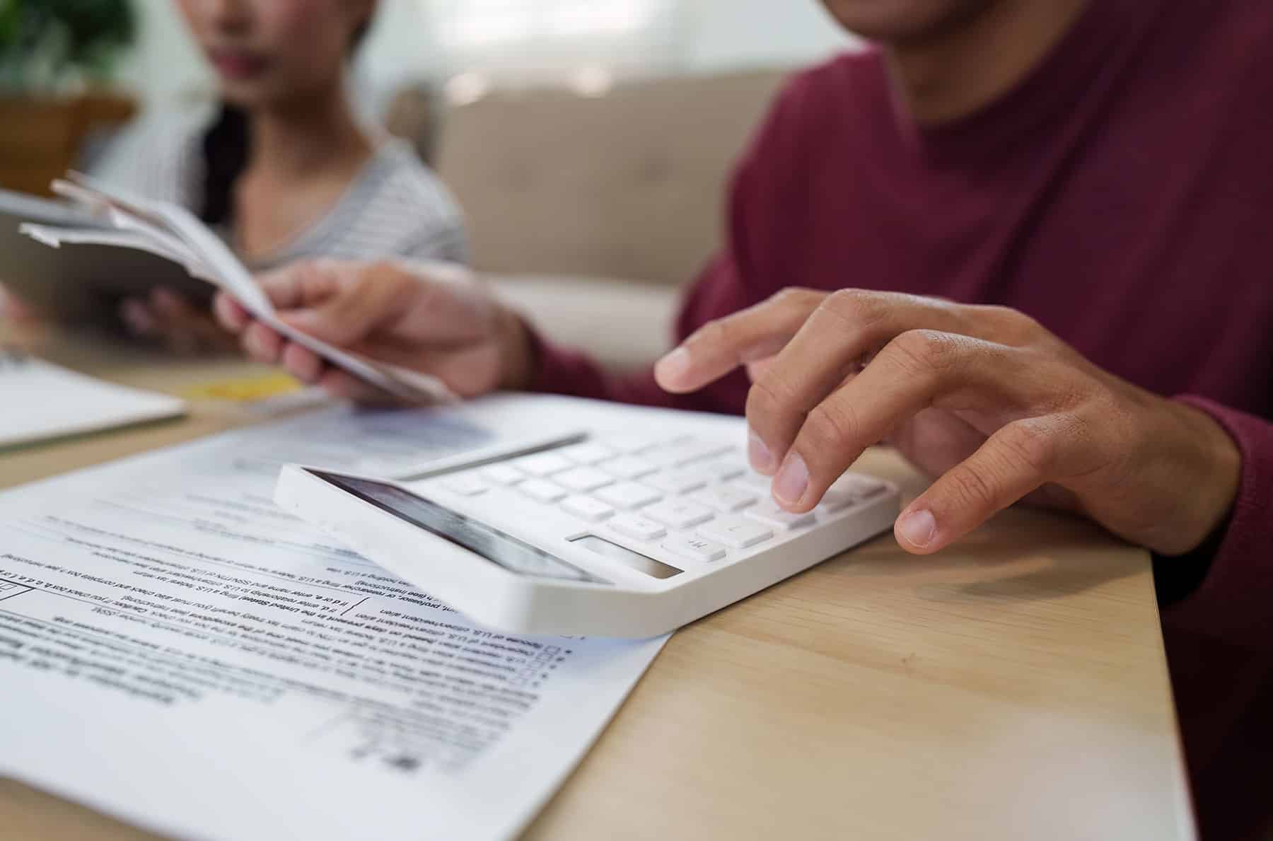 Man Using Calculator to Compute Finances