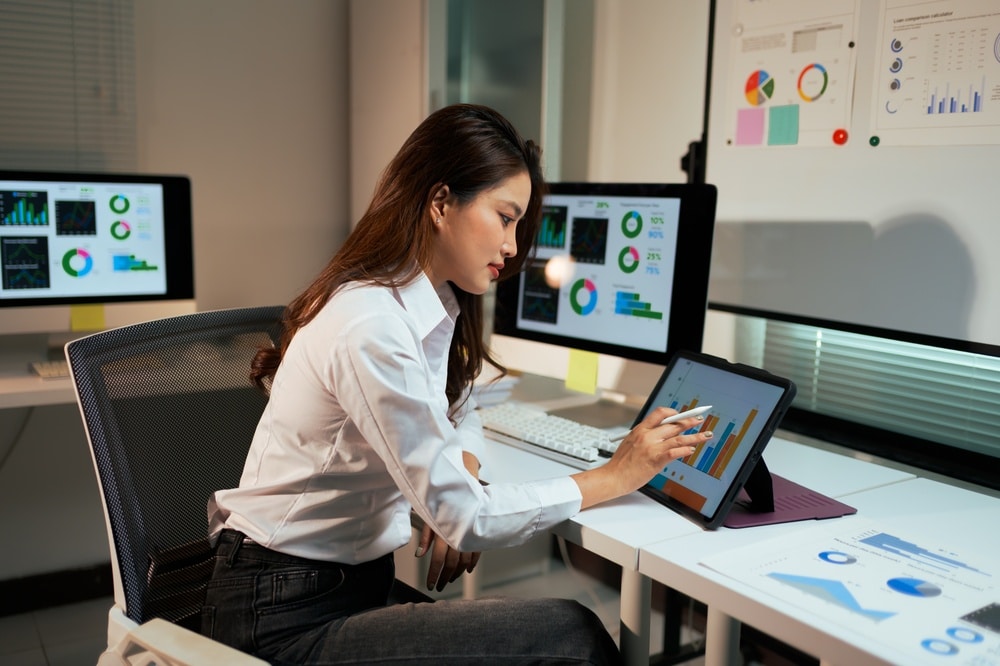 business woman analyzing financial data and charts on screen