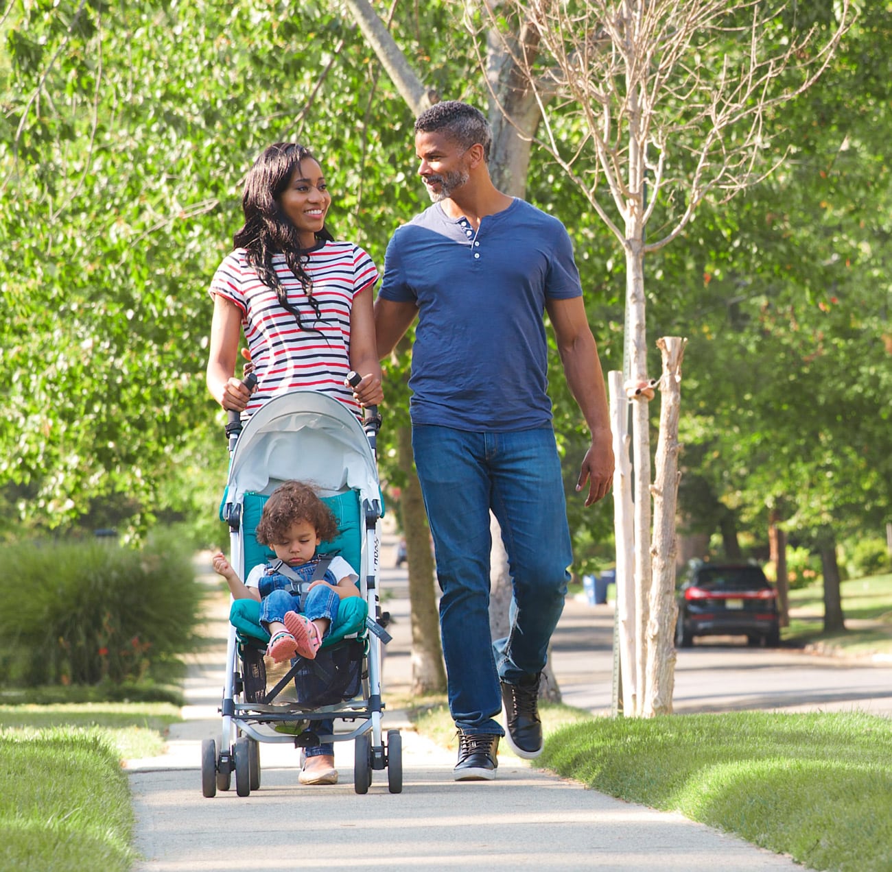 couple and child walking along sidewalk