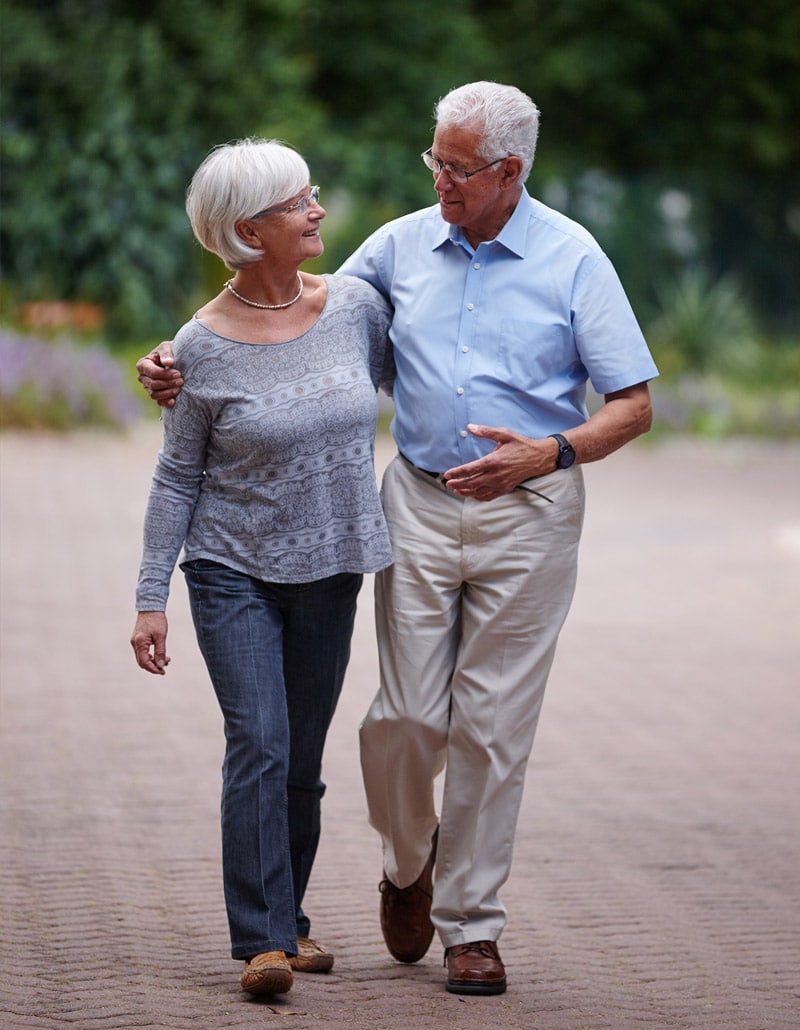elderly couple talking while walking
