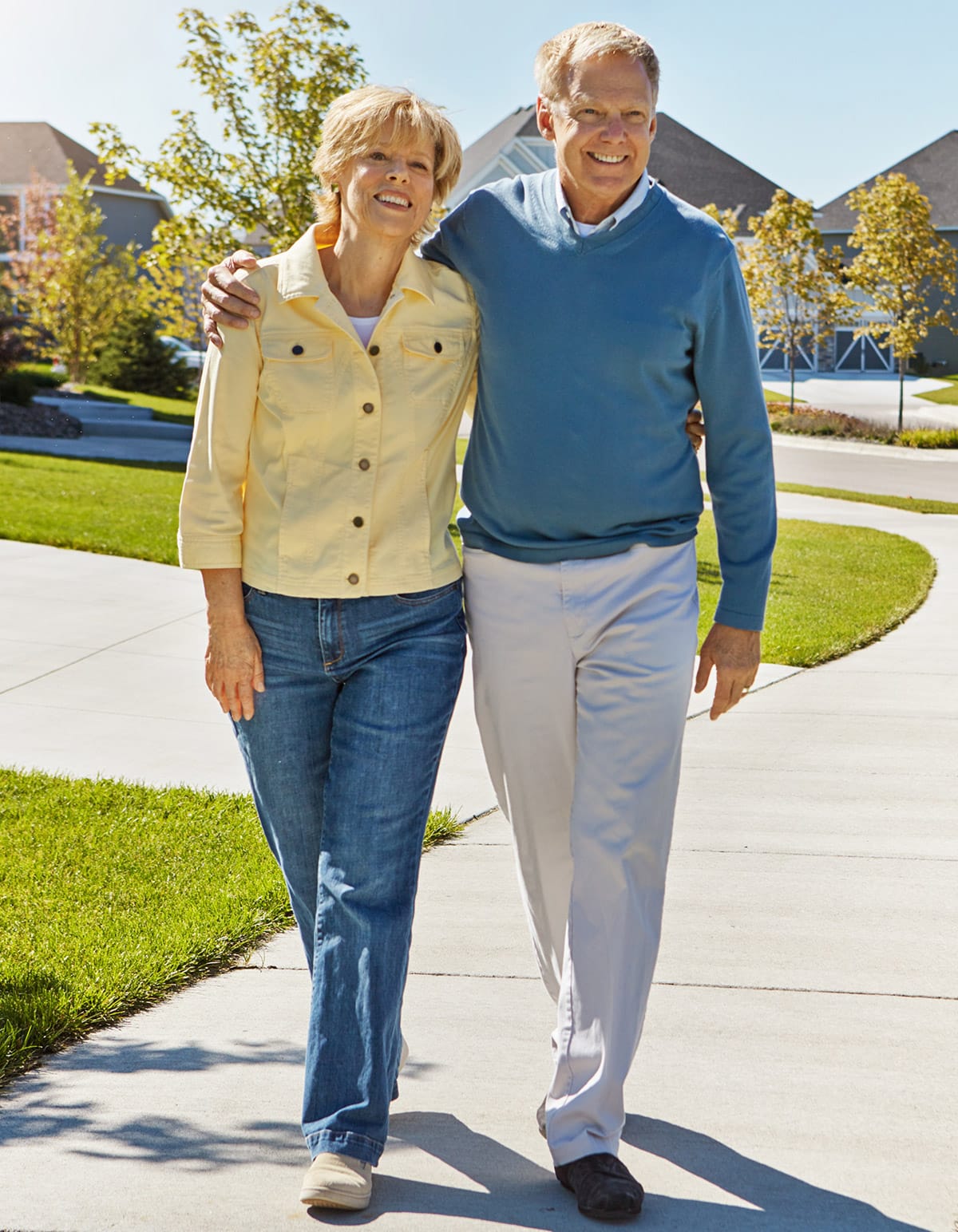 elderly couple walking along neighborhood