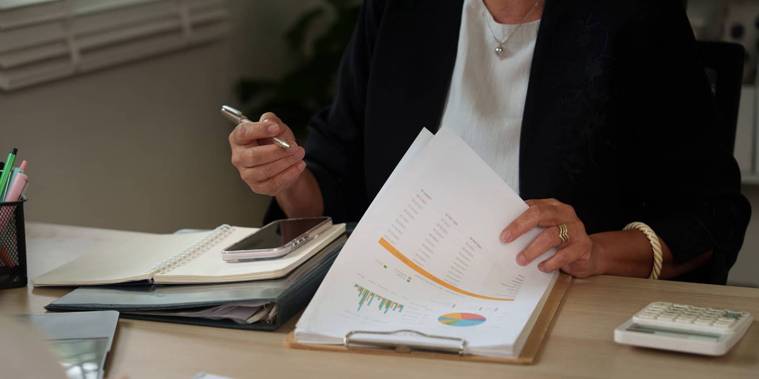 fiduciary reviewing accounting documents and statistics at office desk