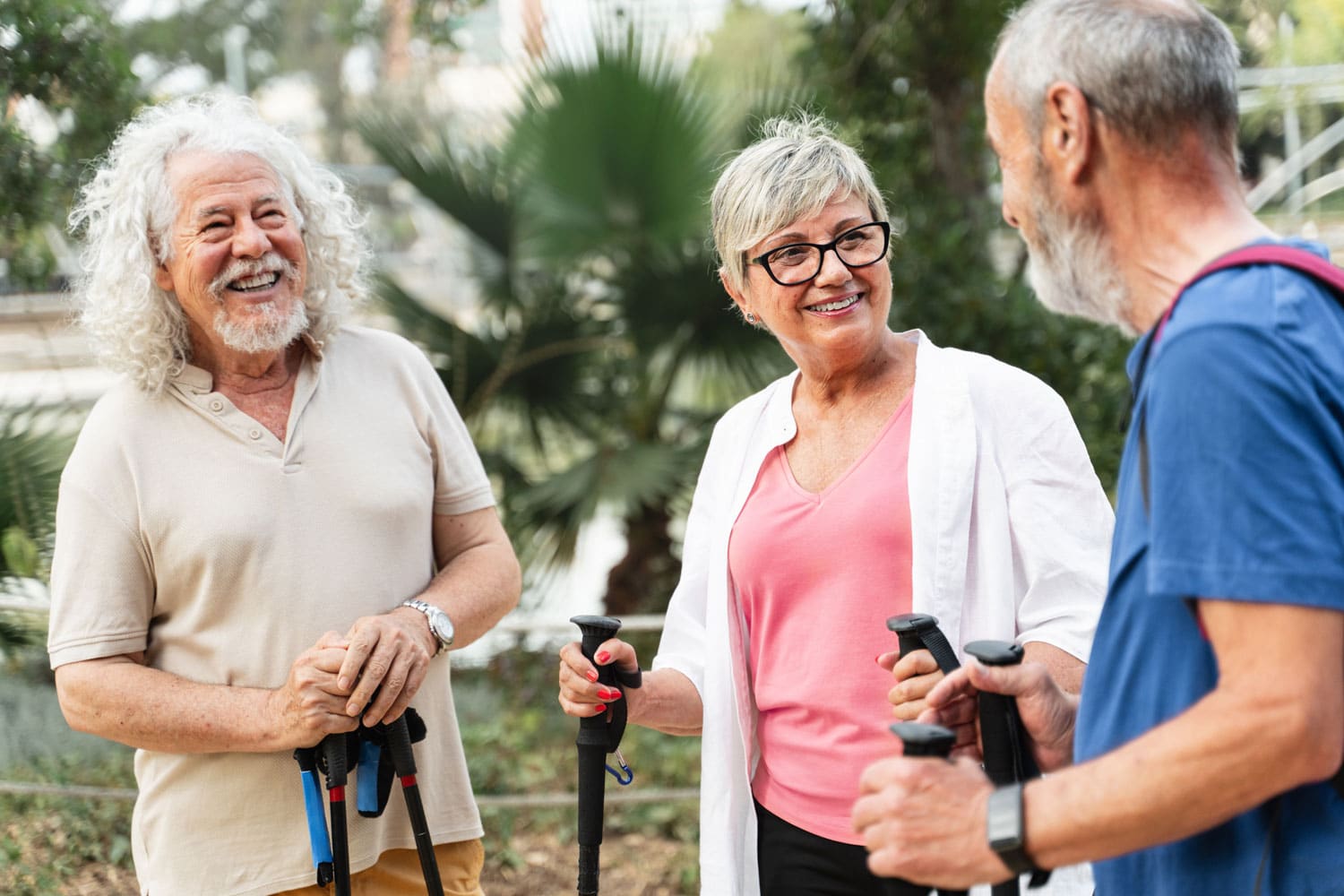 Three elderly individuals smiling and talking