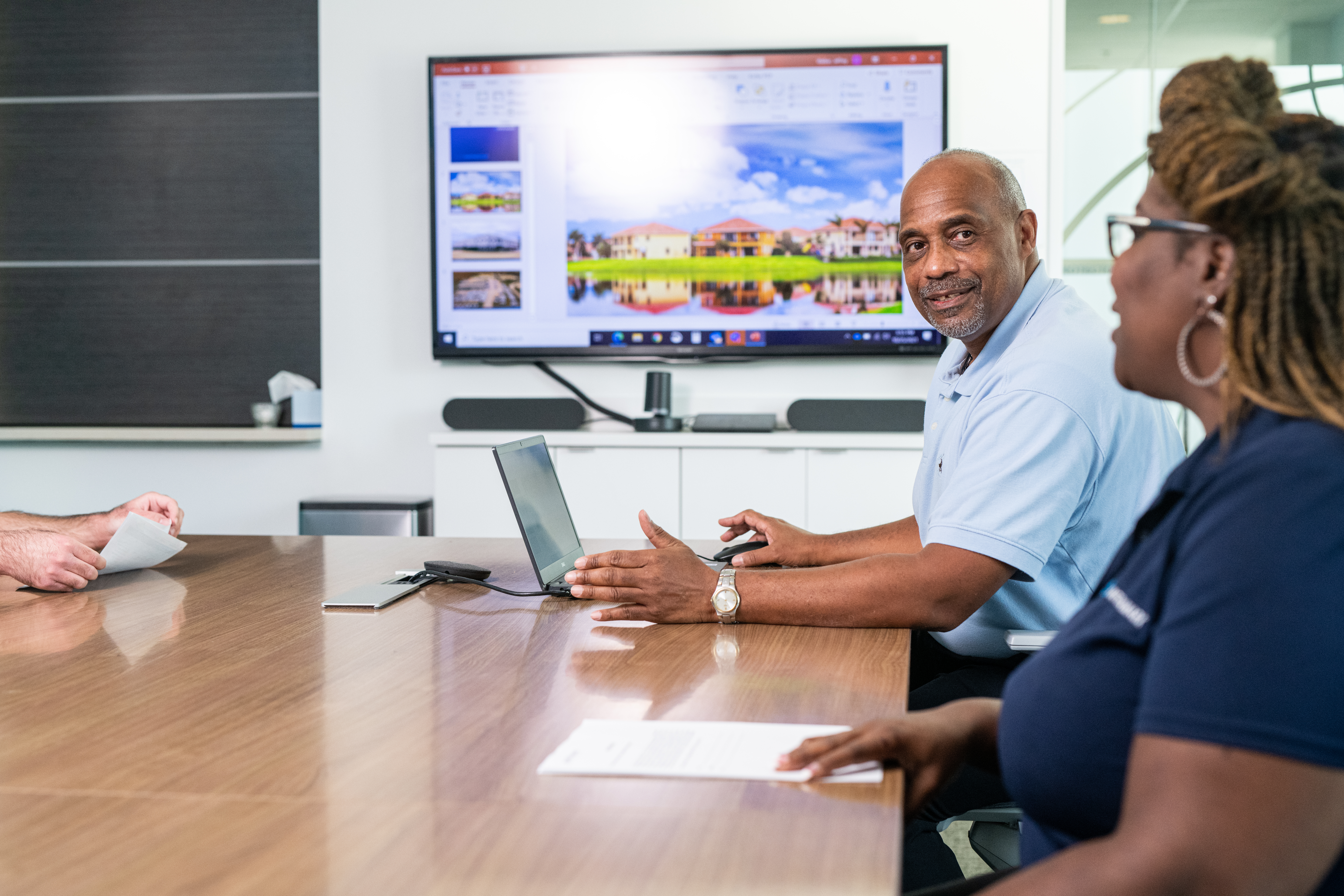 Team meeting with professionals reviewing a presentation on a screen