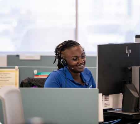 women on the phone with a headset in front of the computer