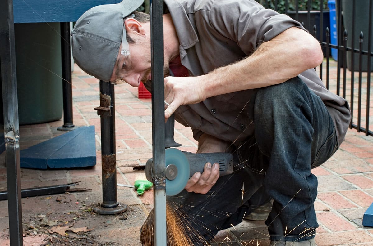 maintenance worker fixing metal fence