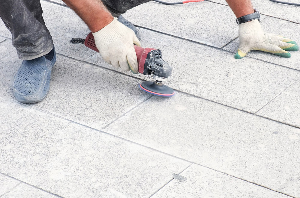maintenance worker grinding sidewalk