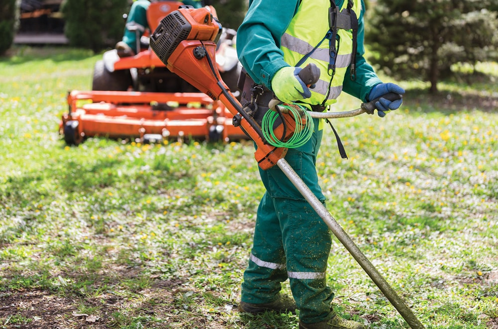 maintenance worker mowing neighborhood grass
