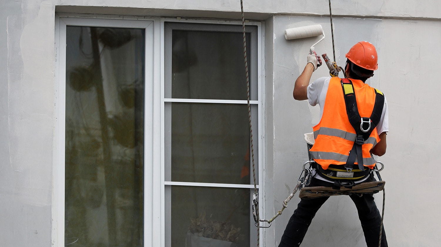 maintenance worker painting apartment building