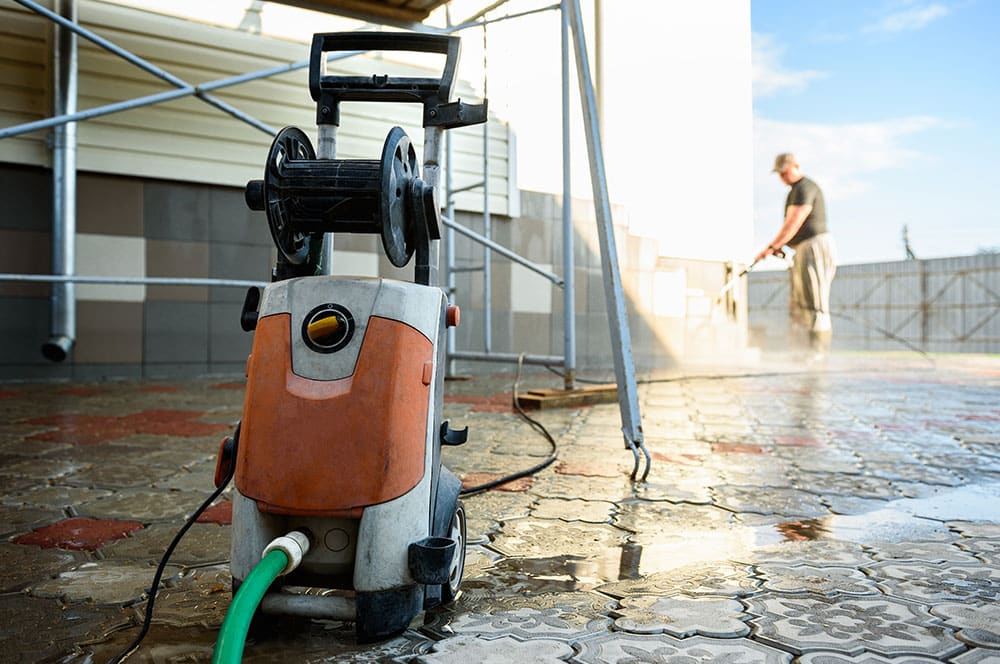 maintenance worker pressure washing building