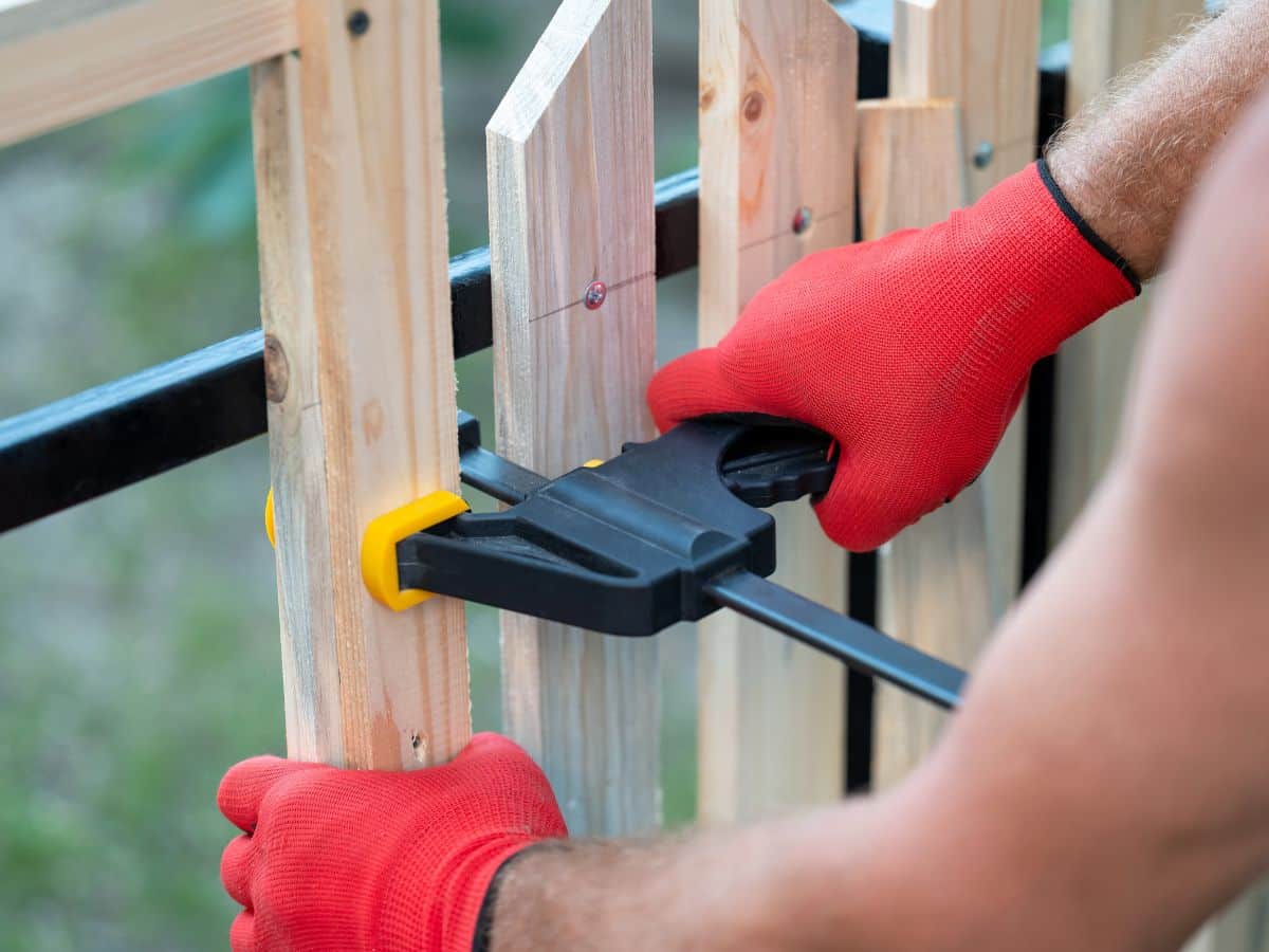 maintenance worker repairing picket fence