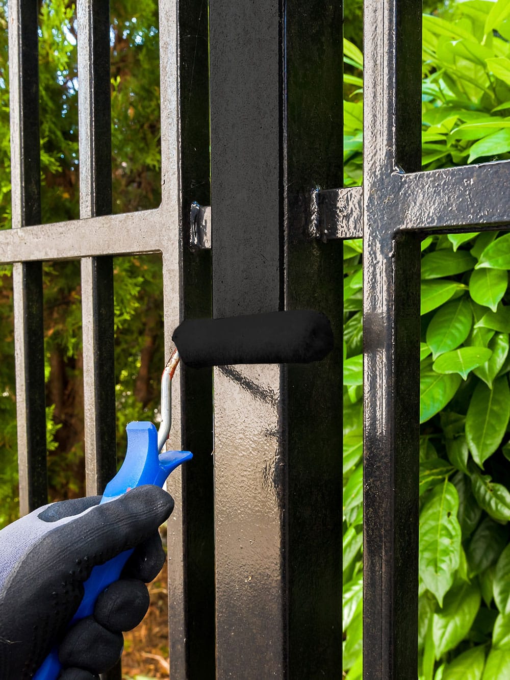 man painting metal fence