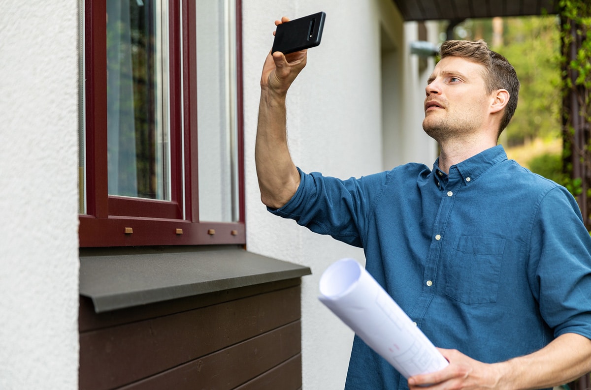 man taking photo of houses