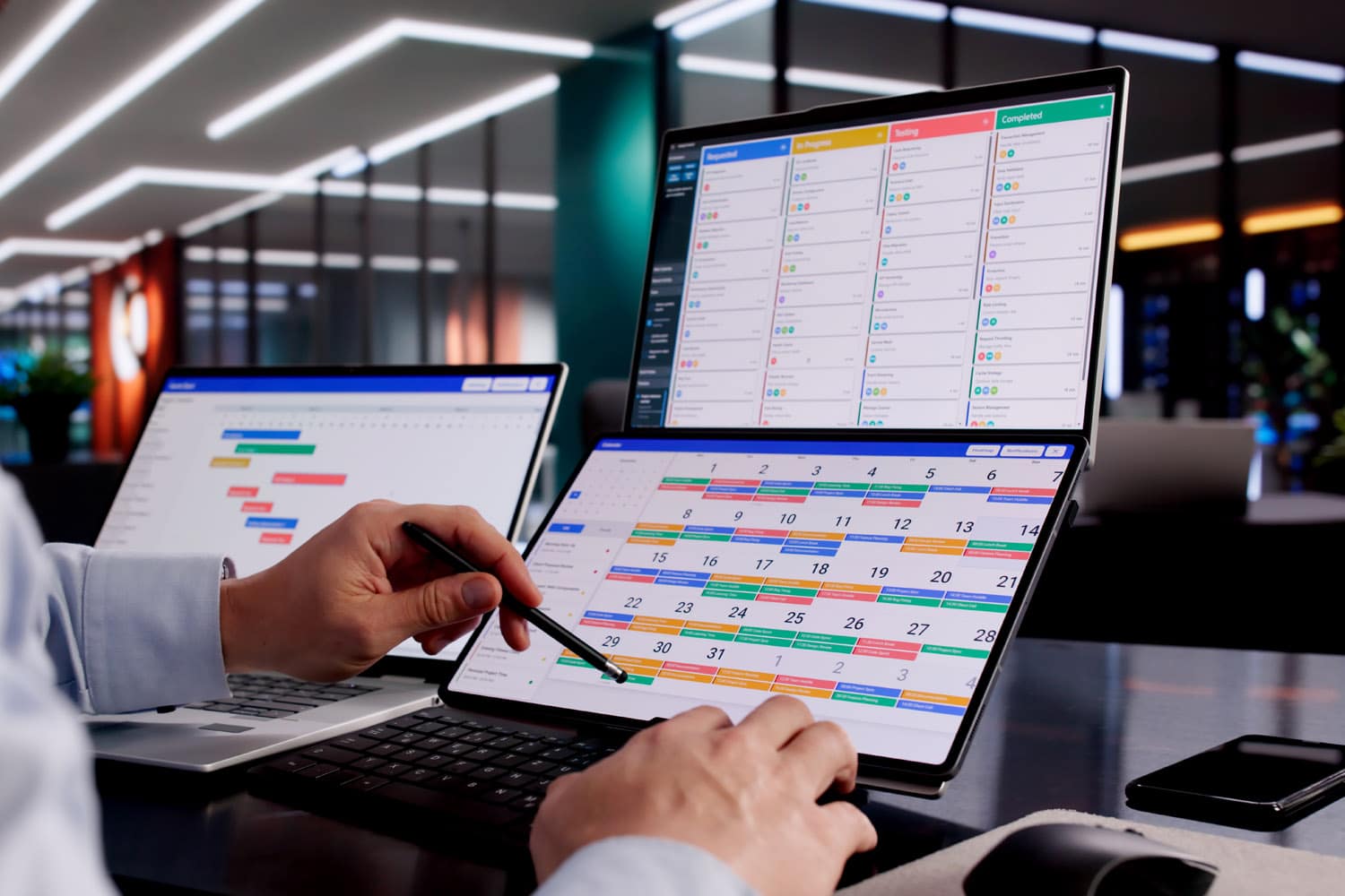 manager using digital calendar scheduling on tablet and laptop
