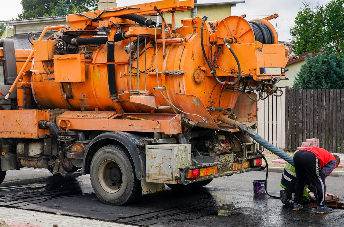 orange vacuum truck in neighborhood