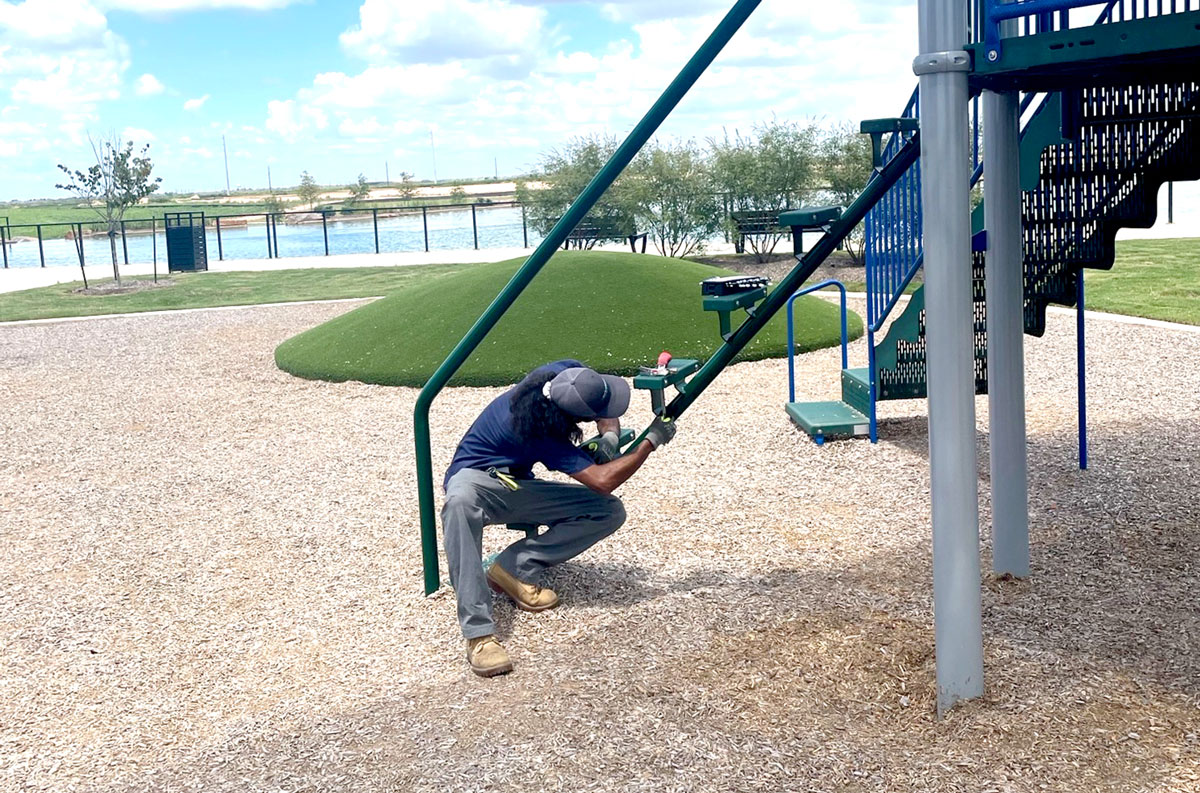 porter fixing playground slide