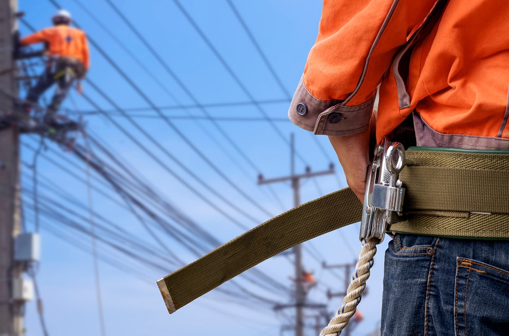 public utility worker looking over electric pole