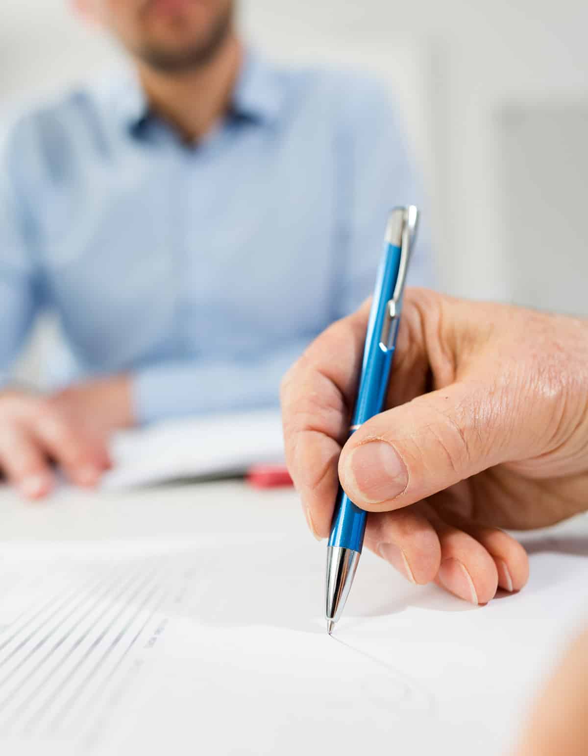 woman writing on contract client in meeting